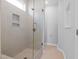 Contemporary shower featuring tiled walls, a frameless glass door, and built-in shelving at 1829 Hydrangea Way, Fuquay Varina, NC 27526