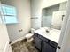 Bright bathroom with a single vanity, ample storage, and a large window at 214 Drayton Hall Ln, Sanford, NC 27330