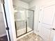 Modern bathroom with glass-enclosed shower, neutral walls, and ceramic tile floors at 214 Drayton Hall Ln, Sanford, NC 27330