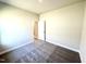 Cozy bedroom with neutral walls, plush carpet, and an open doorway at 214 Drayton Hall Ln, Sanford, NC 27330