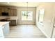 Bright eating area with a view, next to kitchen area with gray cabinetry and a window over the sink at 214 Drayton Hall Ln, Sanford, NC 27330