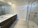 Bathroom featuring a double vanity, shower, and neutral toned tile floor at 224 Bering Cir, Angier, NC 27501