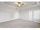 A spacious bedroom features plush carpeting and a tray ceiling with a fan at 32 Boyce Ct, Sanford, NC 27332