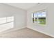 Bright, sunlit carpeted bedroom with a large window showcasing a view of outside at 32 Boyce Ct, Sanford, NC 27332