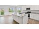 Kitchen features island with granite counters, stainless steel appliances, white cabinets, and wainscotting at 32 Boyce Ct, Sanford, NC 27332