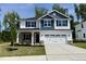 Charming two-story home featuring a two-car garage, stone accents, and a well-manicured lawn at 335 Bishop Ln, Sanford, NC 27330