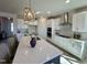 Modern kitchen with a large island, white cabinets, stainless steel appliances, and elegant lighting at 225 Bering Cir, Angier, NC 27501