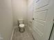 Tiled powder room with a standard toilet and a white door at 225 Bering Cir, Angier, NC 27501