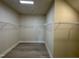 Spacious walk-in closet with a rod and shelf system and light vinyl flooring at 225 Bering Cir, Angier, NC 27501