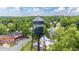 Aerial view of the Glencoe water tower surrounded by trees and houses under a sunny sky at 2416 Glencoe St, Burlington, NC 27217