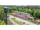 Aerial view of a building with a parking lot, water tower and lush green trees at 2416 Glencoe St, Burlington, NC 27217