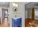 Updated bathroom with blue vanity, blue round mirror, modern light fixture, and hardwood floors at 2416 Glencoe St, Burlington, NC 27217