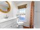 Bright bathroom with white vanity, medicine cabinet, decorative mirror, and window for natural light at 2416 Glencoe St, Burlington, NC 27217