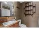 Charming bathroom features wood paneled walls, wood vanity, toilet, and rustic shelving at 2416 Glencoe St, Burlington, NC 27217