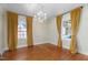 Bright dining room features hardwood floors, chandelier, and two windows with yellow drapes at 2416 Glencoe St, Burlington, NC 27217