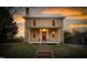 Charming two-story home featuring a welcoming front porch and beautiful sunset sky at 2416 Glencoe St, Burlington, NC 27217