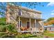 Charming two-story home with a covered front porch, landscaping, and seasonal flowers at 2416 Glencoe St, Burlington, NC 27217