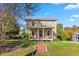 Charming two-story home with a large front yard, brick walkway, covered porch, and mature trees at 2416 Glencoe St, Burlington, NC 27217