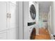 Modern laundry area with stacked washer/dryer and sleek storage cabinets with gold hardware at 2416 Glencoe St, Burlington, NC 27217