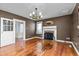 Cozy living room with hardwood floors, fireplace with brick surround, and overhead chandelier at 2416 Glencoe St, Burlington, NC 27217