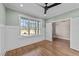Study or bedroom with large window and decorative wall paneling, and hardwood floors at 25 Firefly Ln, Youngsville, NC 27596