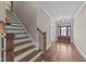 Open foyer and stairway with hardwood floors and a view to the decorative entryway at 25 Firefly Ln, Youngsville, NC 27596
