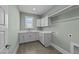 Well-lit laundry room with a window, ample counter space, shaker cabinets, and tile flooring at 25 Firefly Ln, Youngsville, NC 27596