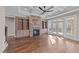 Cozy living room featuring a stone fireplace, hardwood floors, built-in bookshelves, and plenty of natural light at 25 Firefly Ln, Youngsville, NC 27596