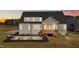 Back of home with screened in porch, stone patio, dark mulch, and newly installed gray siding at 25 Firefly Ln, Youngsville, NC 27596