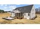 Home's rear exterior showcasing a screened porch, patio, manicured lawn, and elegant gray siding on a sunny day at 25 Firefly Ln, Youngsville, NC 27596