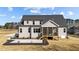 Rear view of home with a screened porch, patio, lush yard, and attractive gray siding under a bright sky at 25 Firefly Ln, Youngsville, NC 27596