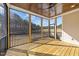 Inviting screened porch featuring a wood ceiling with fan, wood flooring, black railings, and wooded backyard view at 25 Firefly Ln, Youngsville, NC 27596