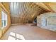 Unfinished room with exposed beams, framing, a window for natural light, and plywood flooring at 25 Firefly Ln, Youngsville, NC 27596