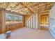 Unfinished room with exposed framing, insulation, a large window, and natural light streaming in at 25 Firefly Ln, Youngsville, NC 27596
