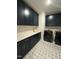Laundry room with dark cabinets, quartz countertops, and patterned tile at 616 Silver Comet Dr, Knightdale, NC 27545