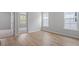 Bright bedroom featuring hardwood floors, two windows, and an open doorway to another room at 707 Georgias Landing Pkwy # 105, Raleigh, NC 27603