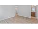 Clean, empty bedroom with light wood floors and view into bathroom and hallway at 707 Georgias Landing Pkwy # 105, Raleigh, NC 27603