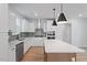 This kitchen is well-equipped with stainless steel appliances, gray backsplash, an island, and bright white cabinetry at 707 Georgias Landing Pkwy # 105, Raleigh, NC 27603