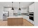 Bright kitchen features stainless appliances, large island with pendant lighting, and ample cabinet space at 707 Georgias Landing Pkwy # 105, Raleigh, NC 27603