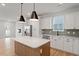 Spacious kitchen with stainless appliances, gray backsplash, a wooden kitchen island, and ample lighting at 707 Georgias Landing Pkwy # 105, Raleigh, NC 27603