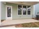 View of a covered patio with a door and three large windows overlooking a lawn at 707 Georgias Landing Pkwy # 105, Raleigh, NC 27603