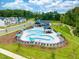 Aerial view of the community swimming pool with lounge chairs and umbrellas on a sunny day at 707 Georgias Landing Pkwy # 105, Raleigh, NC 27603