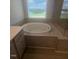 Close-up of a soaking tub next to a glass enclosed shower and granite countertop at 111 Demascus Way # 021, Four Oaks, NC 27524