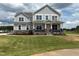Beautiful two-story home featuring stone accents, a welcoming front porch, and lush green lawn at 111 Demascus Way # 021, Four Oaks, NC 27524