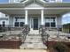 Inviting front porch features stone steps and trim, black iron railings, and a dark entry door at 111 Demascus Way # 021, Four Oaks, NC 27524