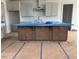 A kitchen features an island with dark wood cabinets, light gray wall cabinets, stainless vent hood and tile backsplash at 111 Demascus Way # 021, Four Oaks, NC 27524