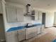 Kitchen area with grey cabinets, light countertops, modern hood and stainless appliances at 111 Demascus Way # 021, Four Oaks, NC 27524