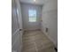 Functional laundry room with wood-look floors, storage shelves, and a bright window at 111 Demascus Way # 021, Four Oaks, NC 27524