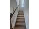 Carpeted staircase with white risers, wooden banister and spindles leading to the upper level of the home at 111 Demascus Way # 021, Four Oaks, NC 27524