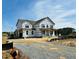 A two-story house under construction, with house wrap and visible window frames on a gravel lot at 111 Demascus Way # 021, Four Oaks, NC 27524